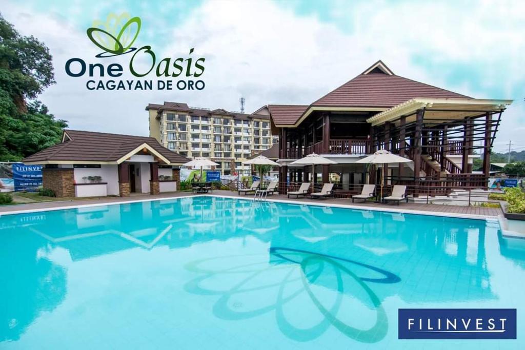 a hotel with a swimming pool in front of a building at One Oasis By Paseo de Corazon Residence in Cagayan de Oro