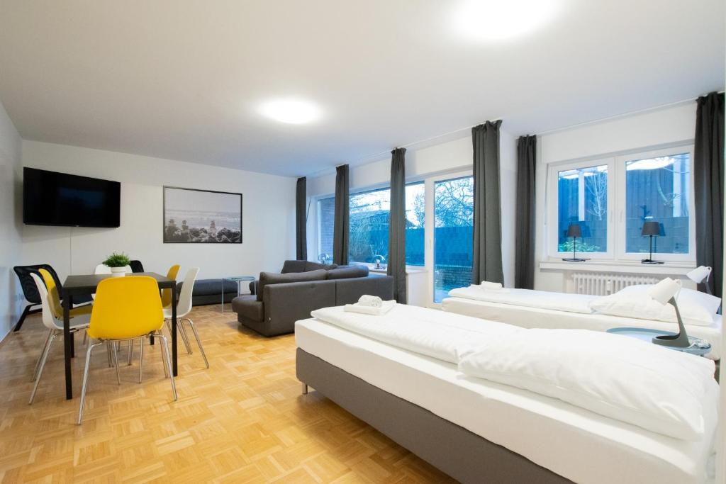 Un dormitorio con dos camas y una sala de estar. en Tolstov Apartments - 1 , 3 and 4 Room Apartments - 20 min Messe DUS & Airport DUS, en Meerbusch