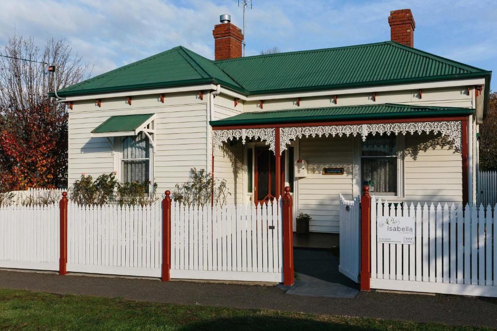 a white house with a fence in front of it at Isabella at Kyneton in Kyneton
