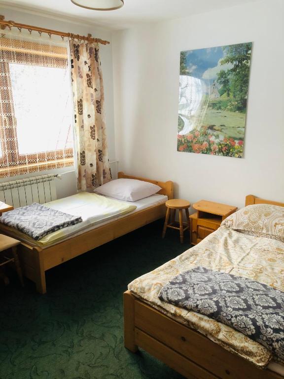 sypialnia z 2 łóżkami i oknem z obrazem w obiekcie U Sobali w mieście Groń