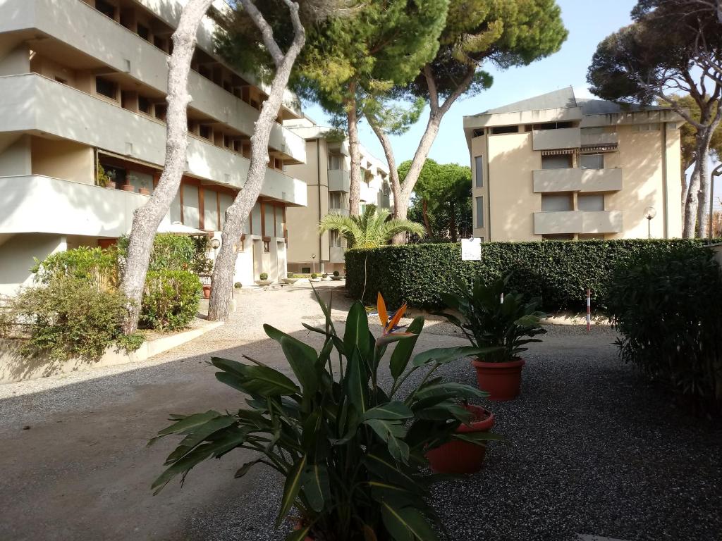 a building with trees and plants in front of it at Caletta Beach in Castiglioncello