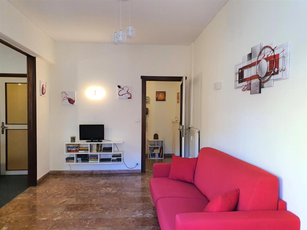 a living room with a red couch and a tv at Centre Home in Rapallo