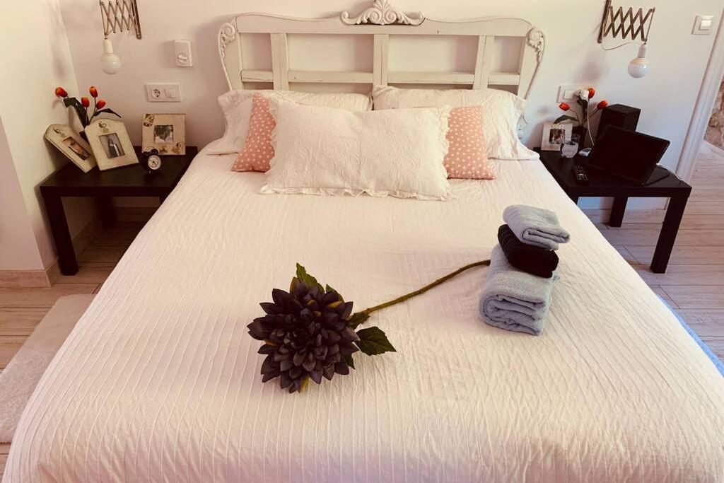 a bedroom with a white bed with towels on it at Casa Tatisita Buhardilla in Segura de la Sierra