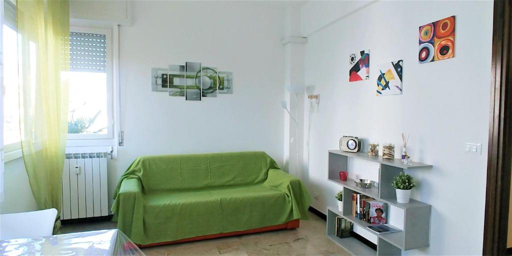 salon z zieloną kanapą i oknem w obiekcie Sun Flat w Rapallo