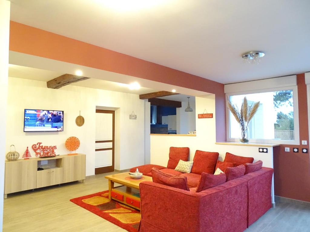 sala de estar con sofá rojo y mesa en Le Panorama - Vue mer, en Criel-sur-Mer