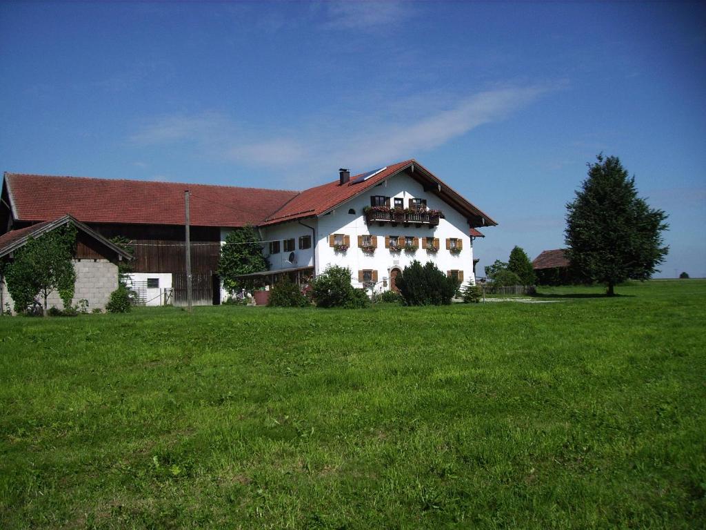 a large white house in a field of green grass at Ferienwohnung Öderhof in Saaldorf