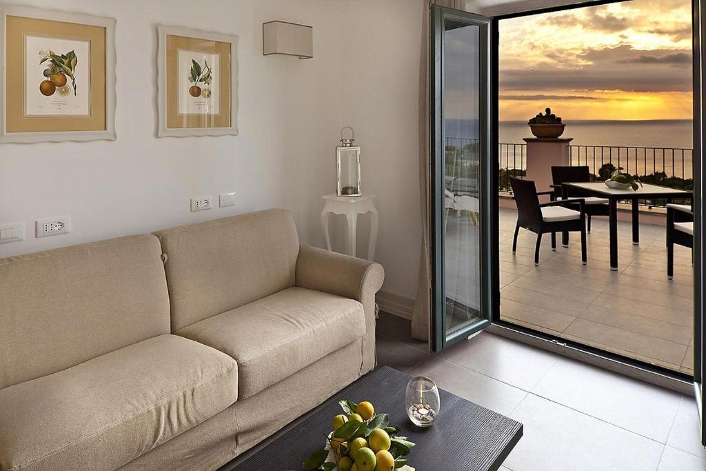 a living room with a couch and a balcony at Tenuta Del Poggio Antico in Ischia