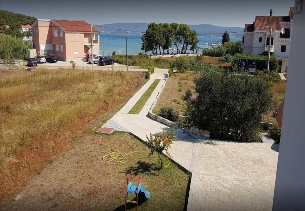 a view of a walkway with a tree in a field at Apartments Den - 100 m from sea in Pašman