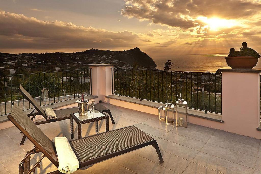 a balcony with a view of the ocean at sunset at Tenuta Del Poggio Antico in Ischia