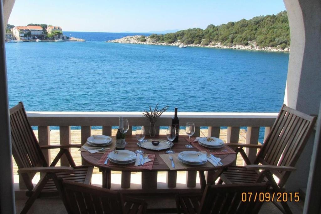a table with wine glasses and a view of the ocean at Apartments Mile - 10m from the sea in Lastovo