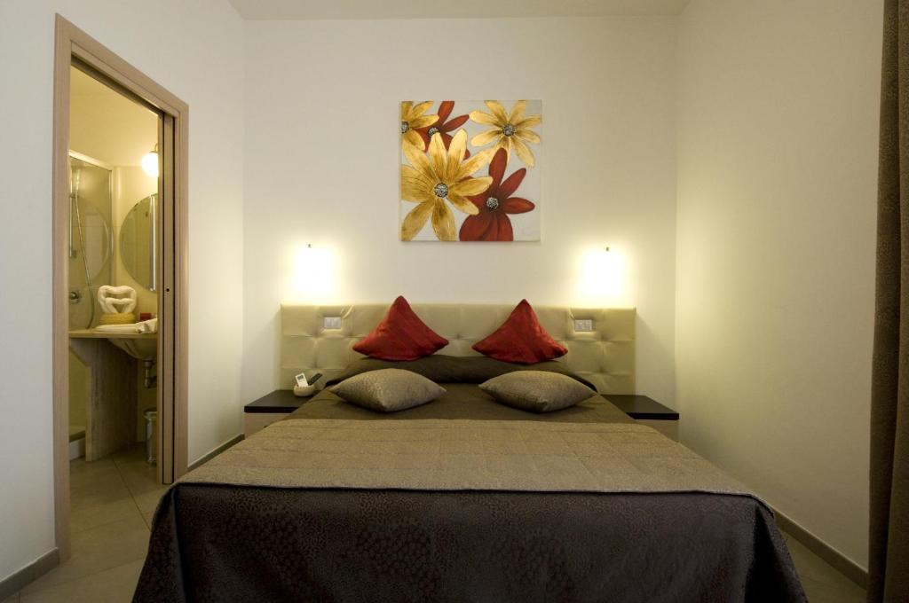 a bedroom with a large bed with red pillows at Ara Pacis Inn in Rome