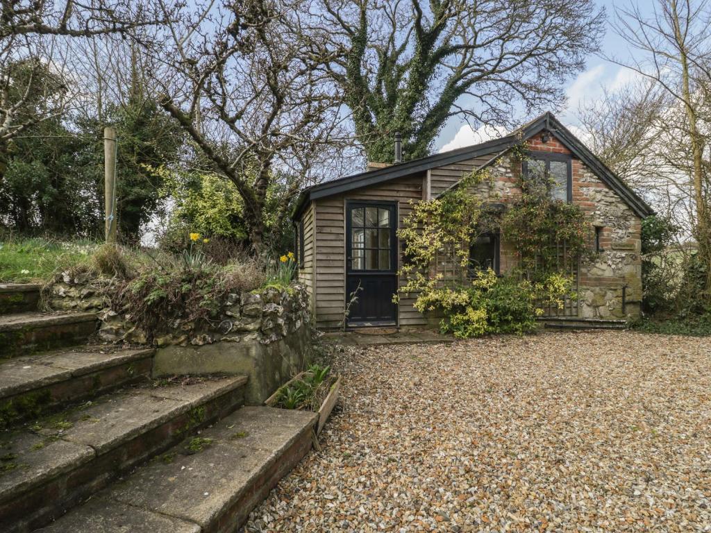 a small stone house with a gravel driveway at The Mouse House in Blandford Forum