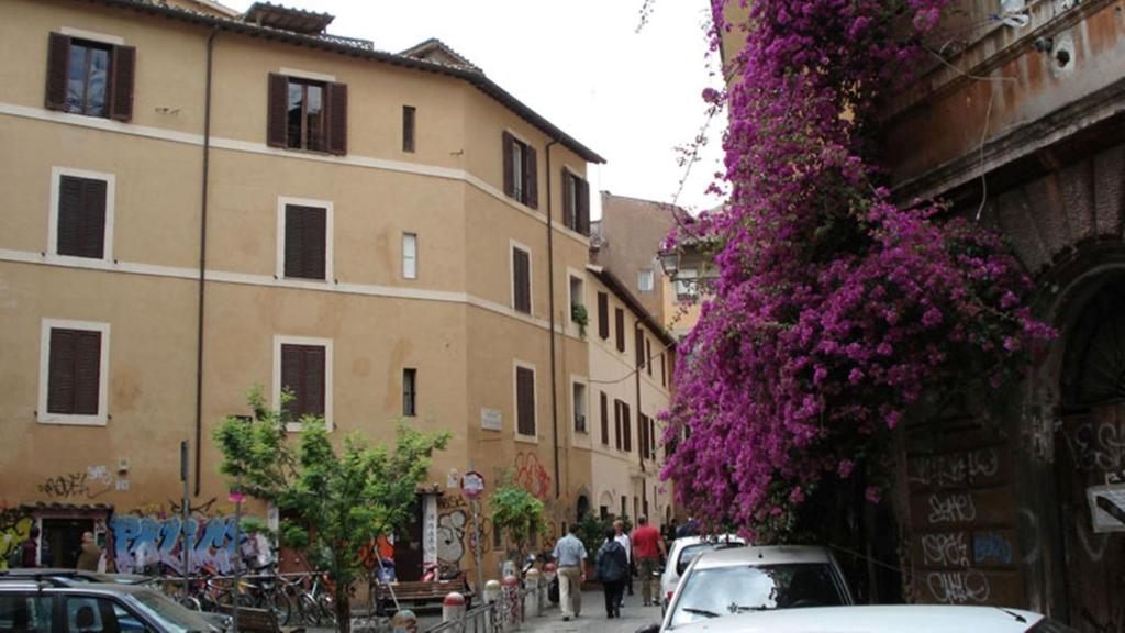 un groupe de voitures garées dans une rue avec des fleurs violettes dans l'établissement Diamonds And Rust, à Rome
