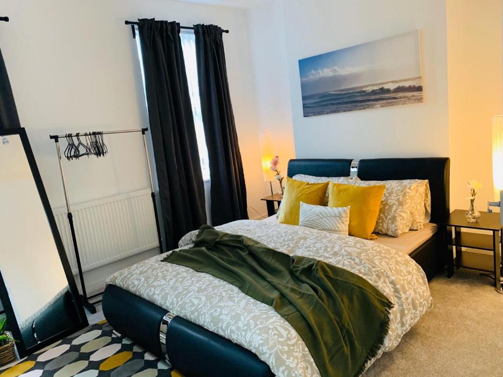 - une chambre avec un grand lit et des oreillers jaunes dans l'établissement Stylish, Spacious & Luxurious Home - Parking, à Liverpool
