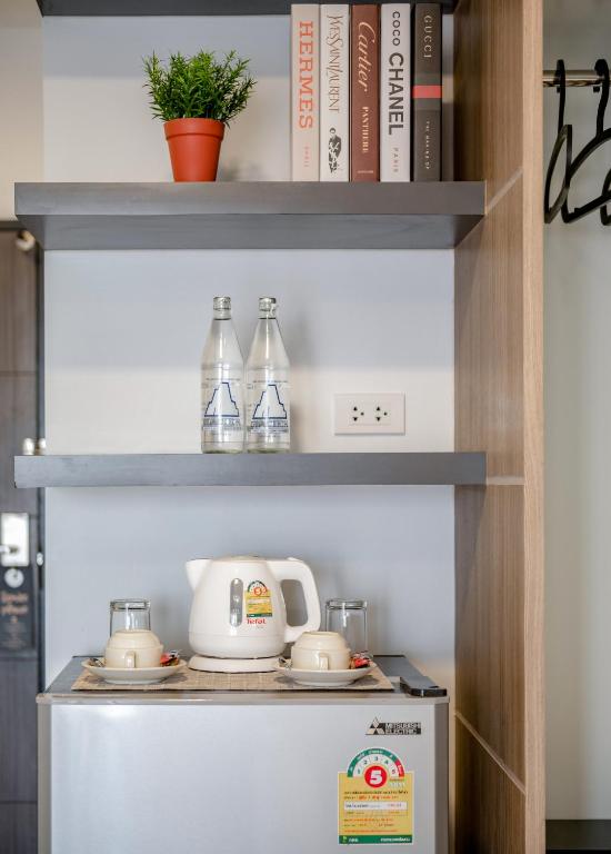 A close view of the room's kettle station, bottled water, cups and wardrobe rail.