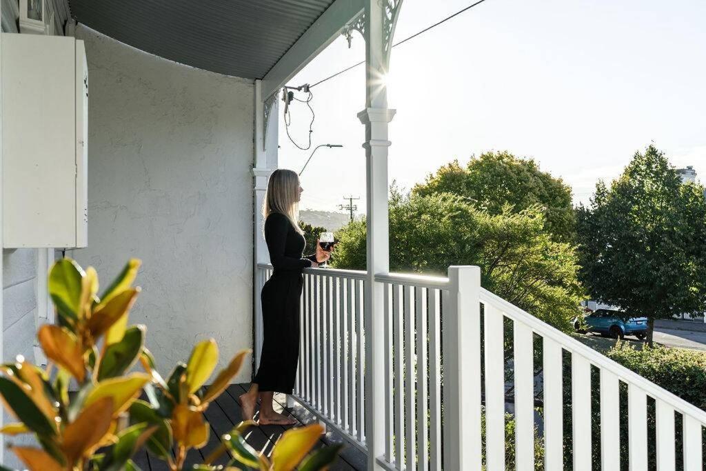 a woman standing on a porch holding a wine glass at The Mistress in Launceston