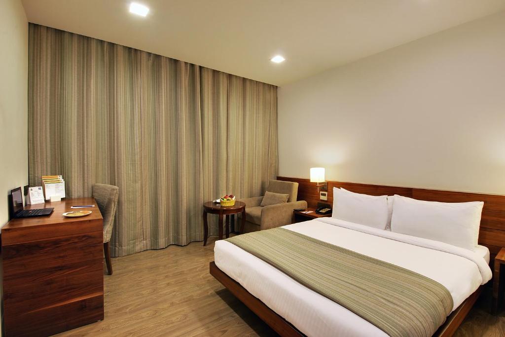 Postel nebo postele na pokoji v ubytování Temple Tree Hotel Shirdi