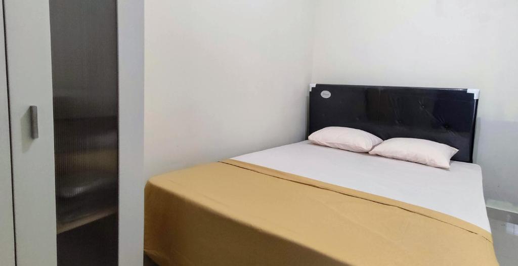 - un petit lit avec 2 oreillers dans l'établissement Choko Homestay, à Colomadu