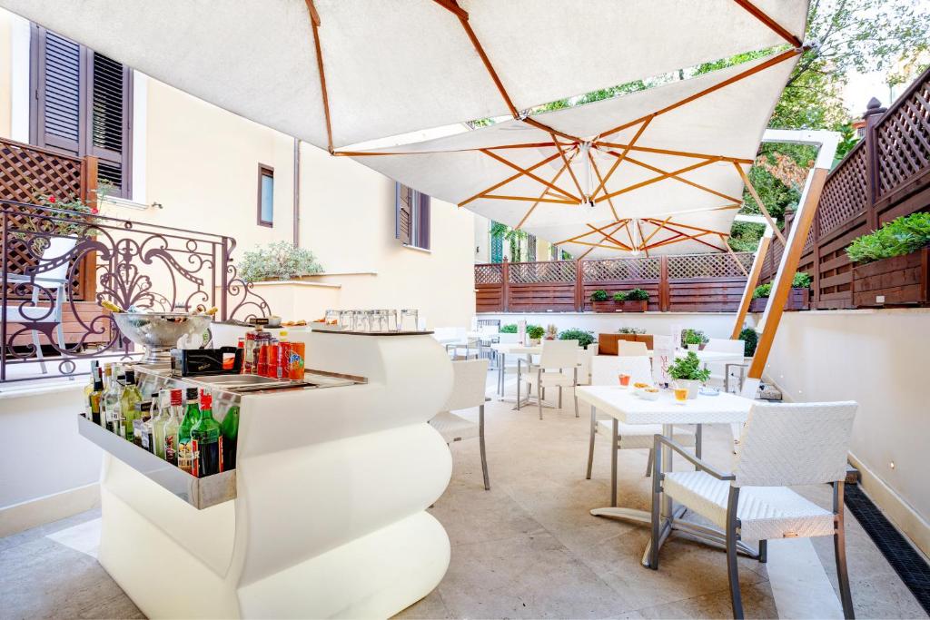 un restaurante con mesas, sillas y sombrilla en Hotel Best Roma en Roma