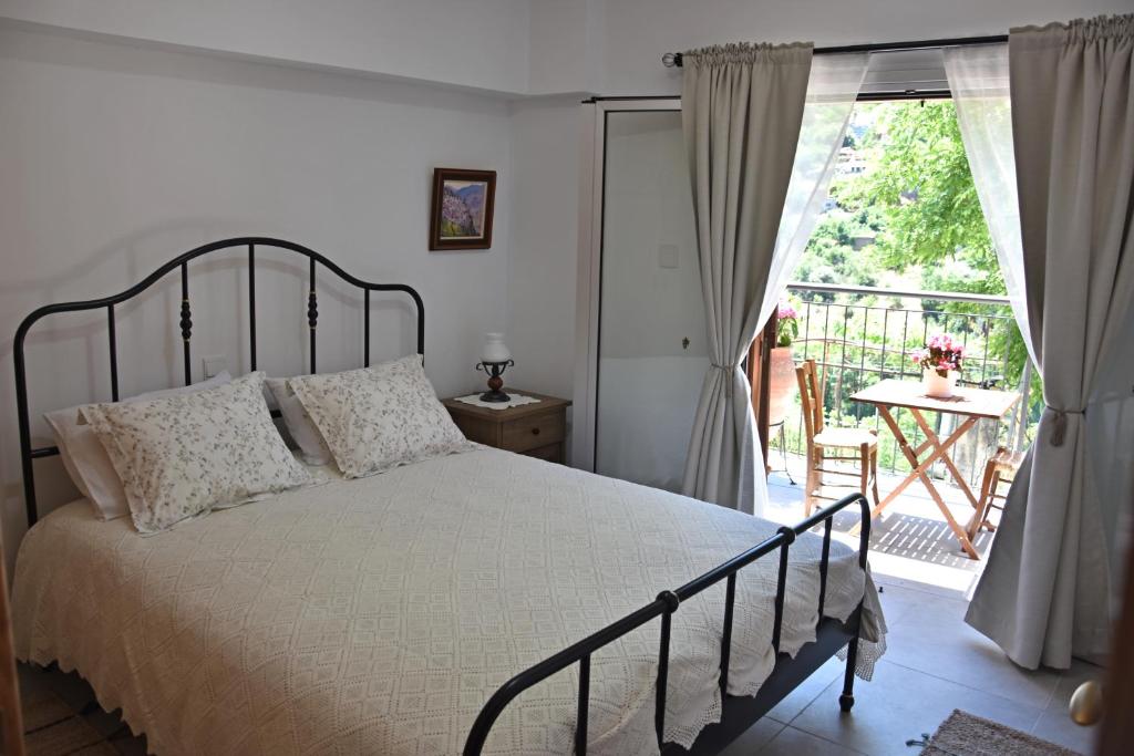 a bedroom with a bed and a balcony at The Old Coffeehouse in Kalopanayiotis
