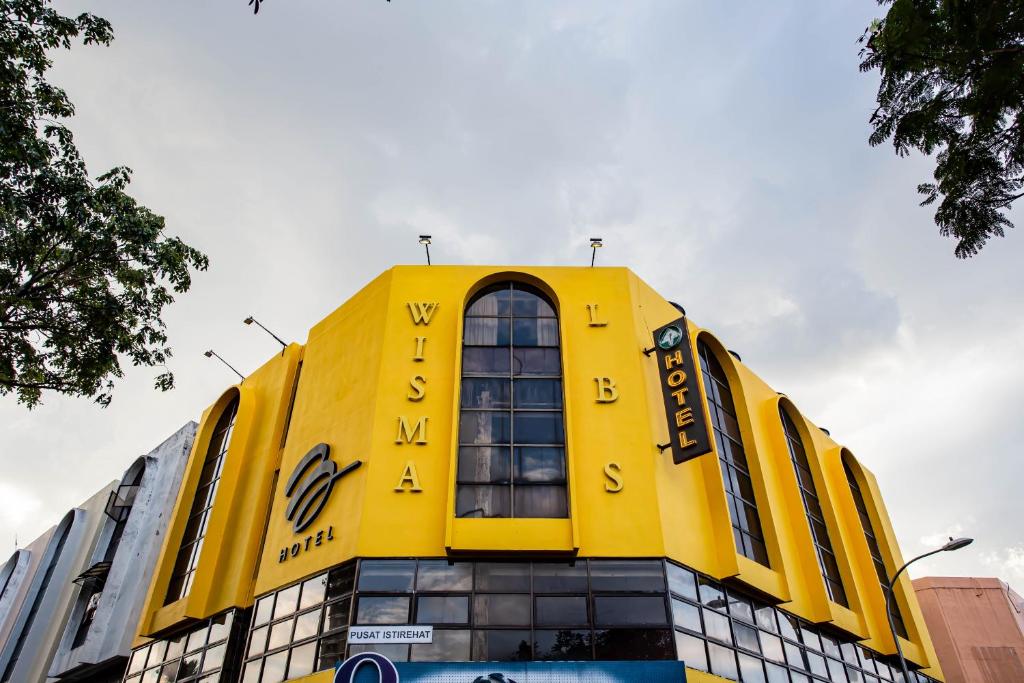 un edificio amarillo con las palabras mykonos en él en BEEZ Hotel Kuala Lumpur en Kuala Lumpur