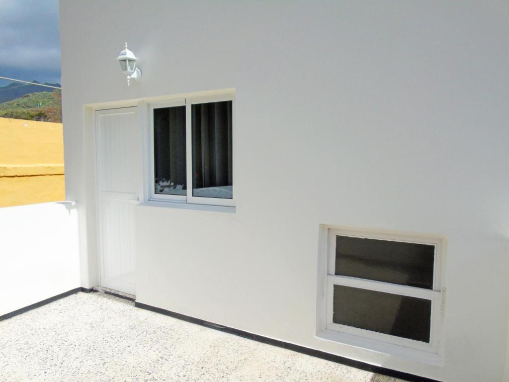 two windows on the side of a white wall at Fleitas Penthouse with terrace in San Andrés