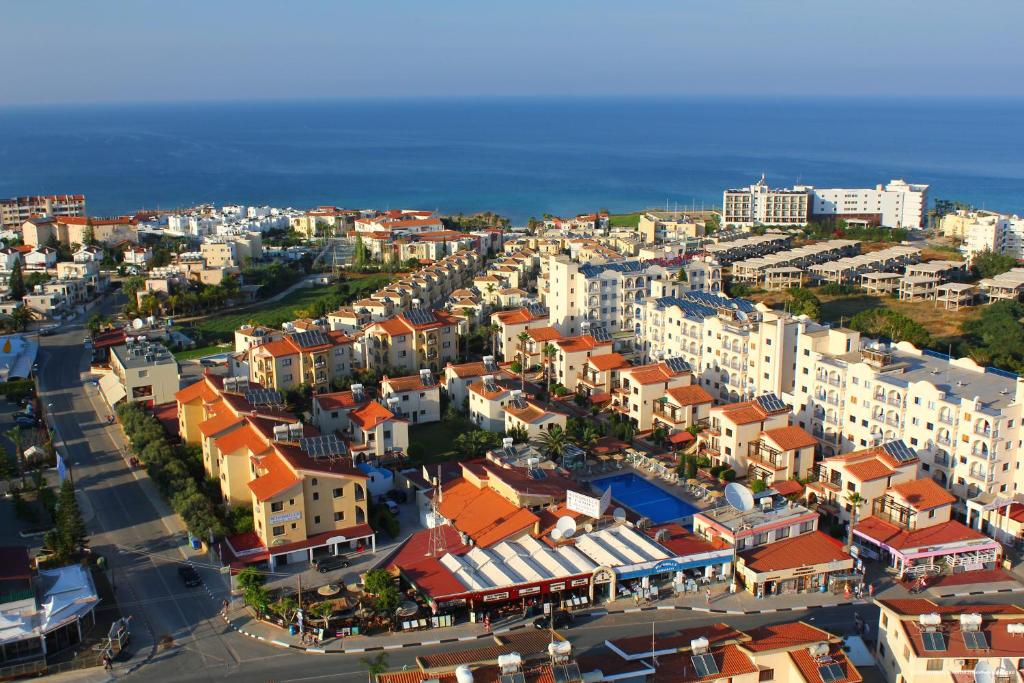 an aerial view of a city with buildings and the ocean at Windmills Hotel Apartments in Protaras