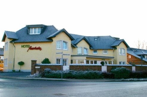 a large house with a roof on a street at Hotel Auerhahn in Pulheim