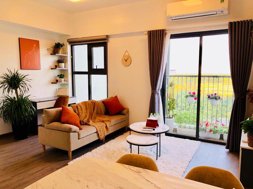 uma sala de estar com um sofá e uma grande janela em BOM HOMES- ECOPARK- SERVICE APARTMENt em Kim Quan