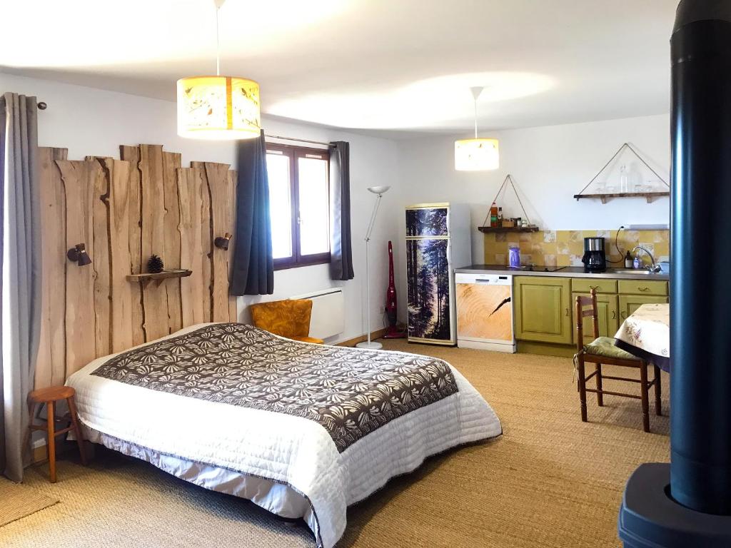 um quarto com uma cama e uma cozinha em Le repaire des Belettes em Chaux-des-Crotenay