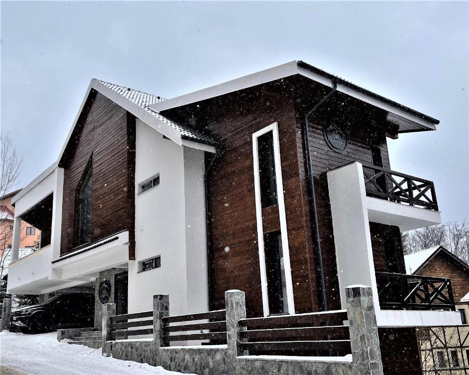 ein Backsteingebäude mit Schnee darauf in der Unterkunft Ama Apartament - Cota 1000 Sinaia in Sinaia