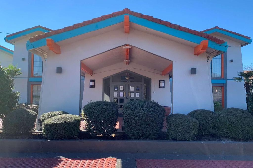 a building with a front door with bushes at Howard Johnson by Wyndham Columbus Fort Moore in Columbus