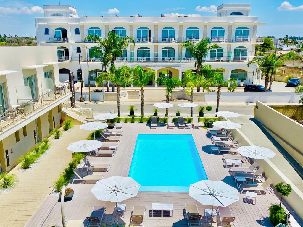 an aerial view of a hotel with a pool and chairs and umbrellas at Hotel Vespucci in Porto Cesareo