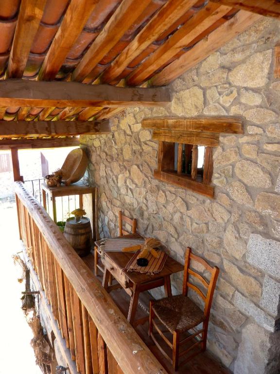 a wooden table and chairs in a stone building at Casa rural calRei in Lles