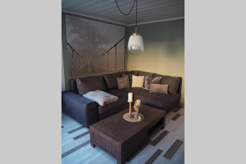 un soggiorno con un divano e un tavolo di Villa Wohli 4 Sterne FERIENWOHNUNG AM HARZ a Nordhausen