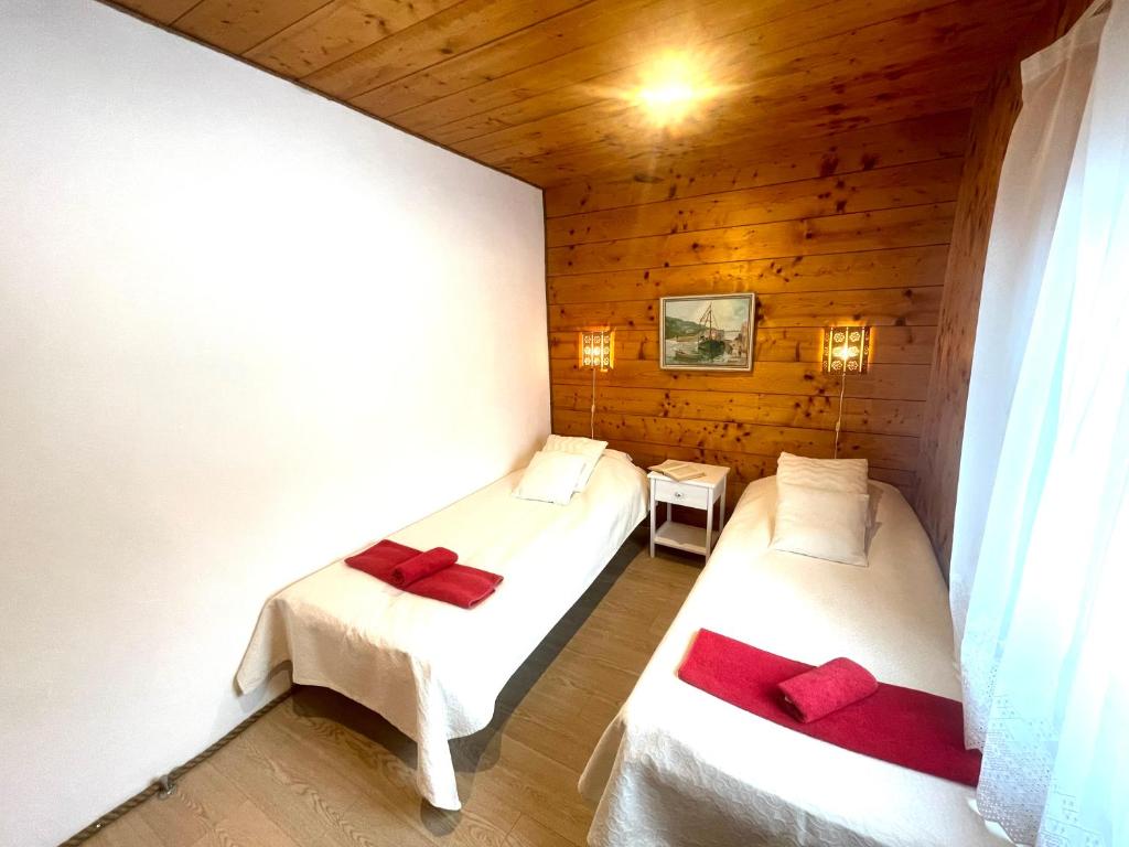 two beds in a room with wooden walls at Nurga Holiday Homes in Käina