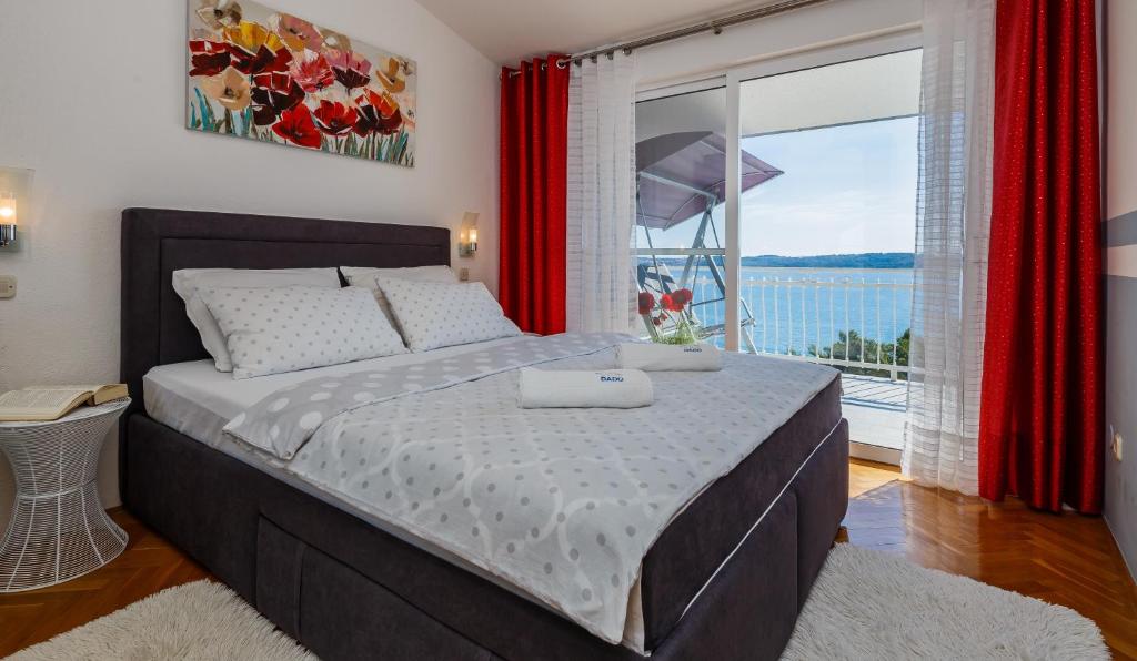 a bedroom with a large bed and a large window at Adriatic Sea View Apartments in Trogir