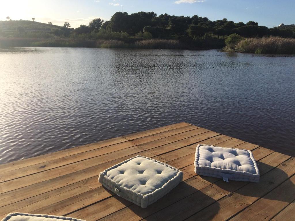 2 letti su un molo accanto a un bacino d'acqua di Quinta da Fornalha - Santuario Agroecologico a Castro Marim