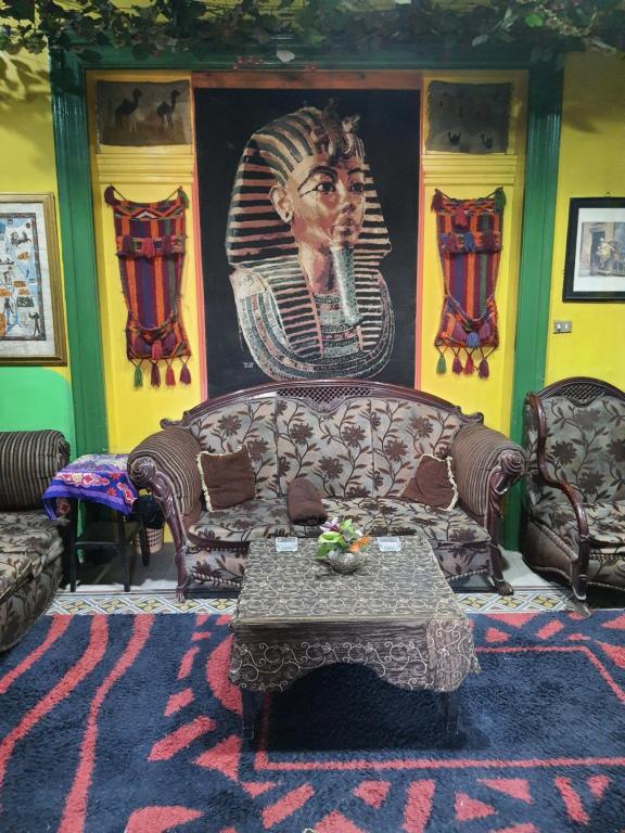 a living room with a couch and a large painting at African House Hostel in Cairo