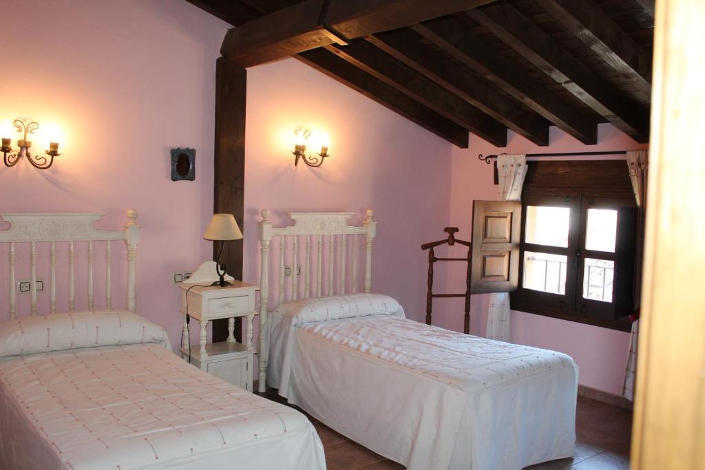 1 dormitorio con 2 camas y ventana en La Escondida, en Tornavacas