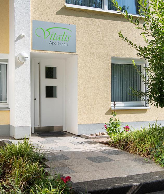 un edificio con una puerta blanca y una señal en él en Vitalis Apartments, en Bad Hersfeld