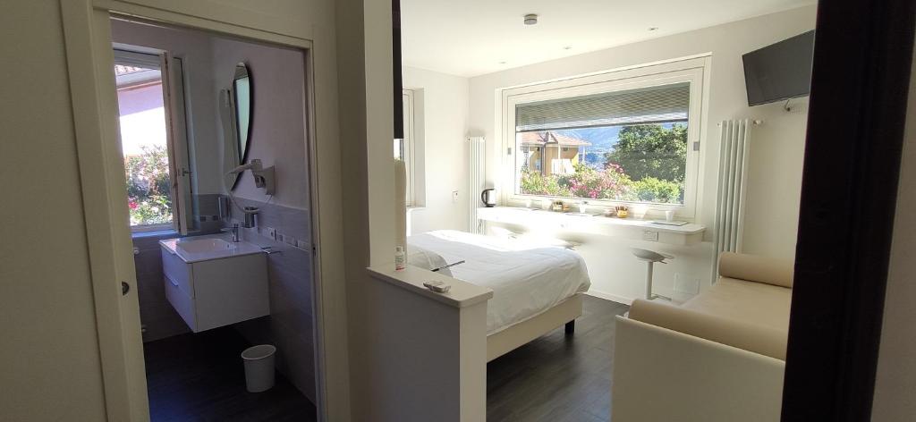 um quarto branco com uma cama e uma janela em Amata Valgre Affittacamere, comfort e pulizia eccezionali!! em Olginate