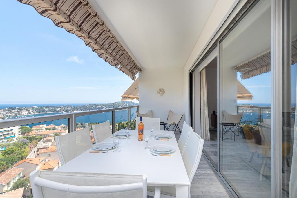 une salle à manger blanche avec une table et des chaises blanches dans l'établissement Sea View Park Swimming Pool & Tennis 2 Bdrs, à Villefranche-sur-Mer