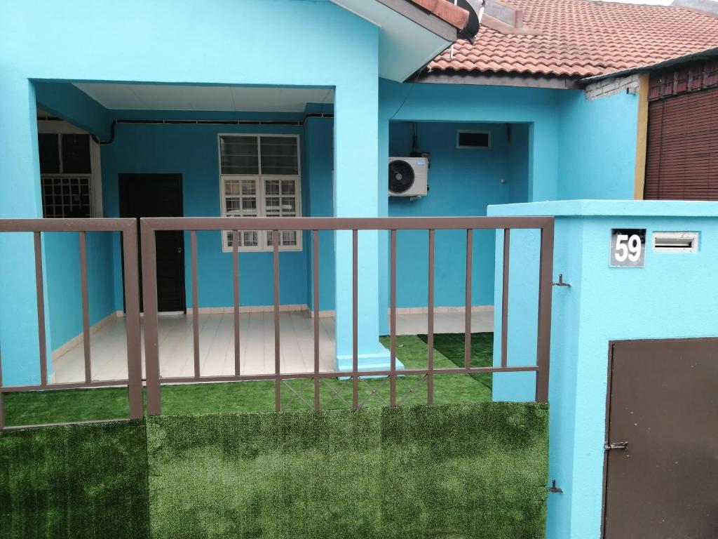 a blue house with a balcony at SKYHOMESTAY TELOK PANGLIMA GARANG in Teluk Panglima Garang