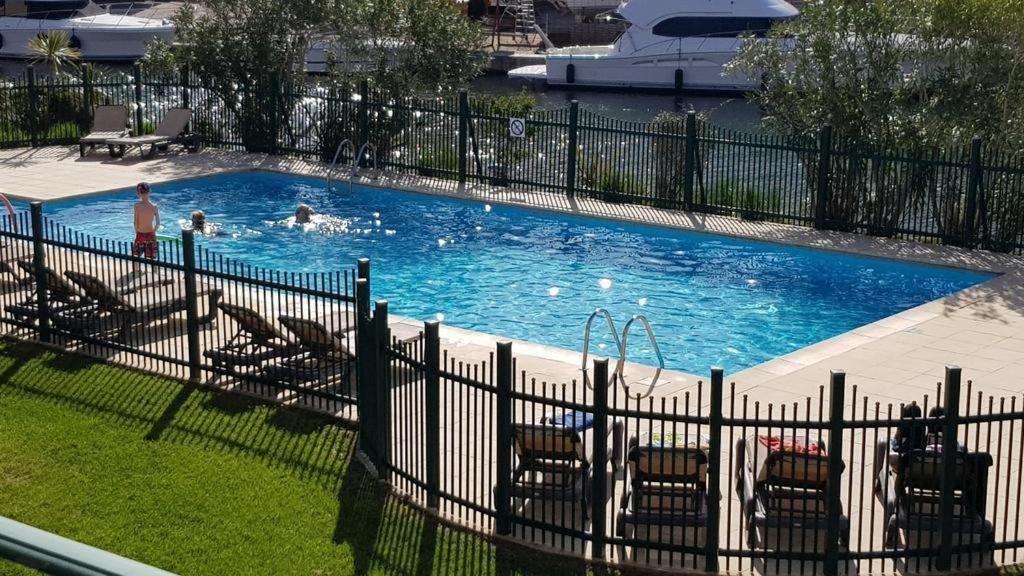 - une piscine avec des chaises et des personnes dans l'établissement APPARTEMENT 4 PERSONNES PORT GRIMAUD - COTE D'AZUR, à Grimaud