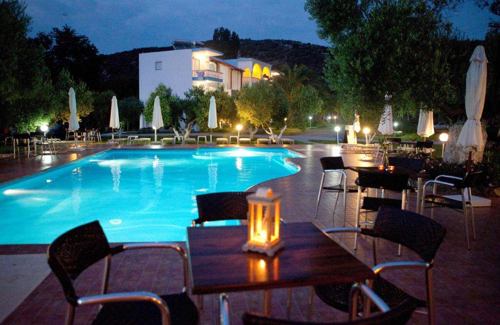 a pool with a wooden table and chairs next to at Haus Risos Next Generation in Toroni