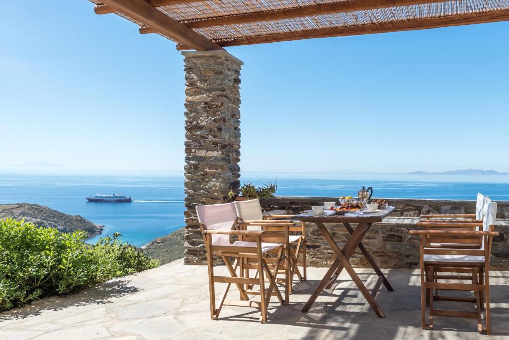 a table and chairs on a patio overlooking the ocean at Evita's Villas-Tinos in Tinos