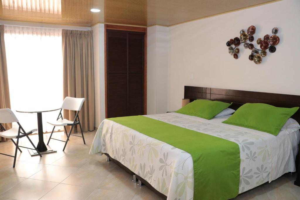 a bedroom with a large bed with green pillows at Hoteles Bogotá Inn Santa Bárbara Usaquén in Bogotá