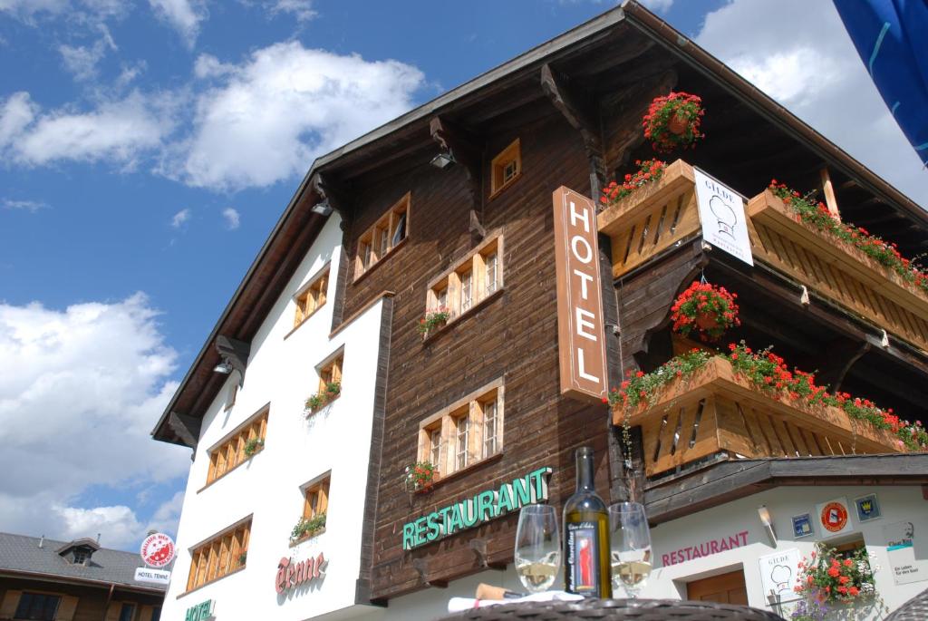 a building with flower boxes on the side of it at Hotel Tenne in Reckingen - Gluringen
