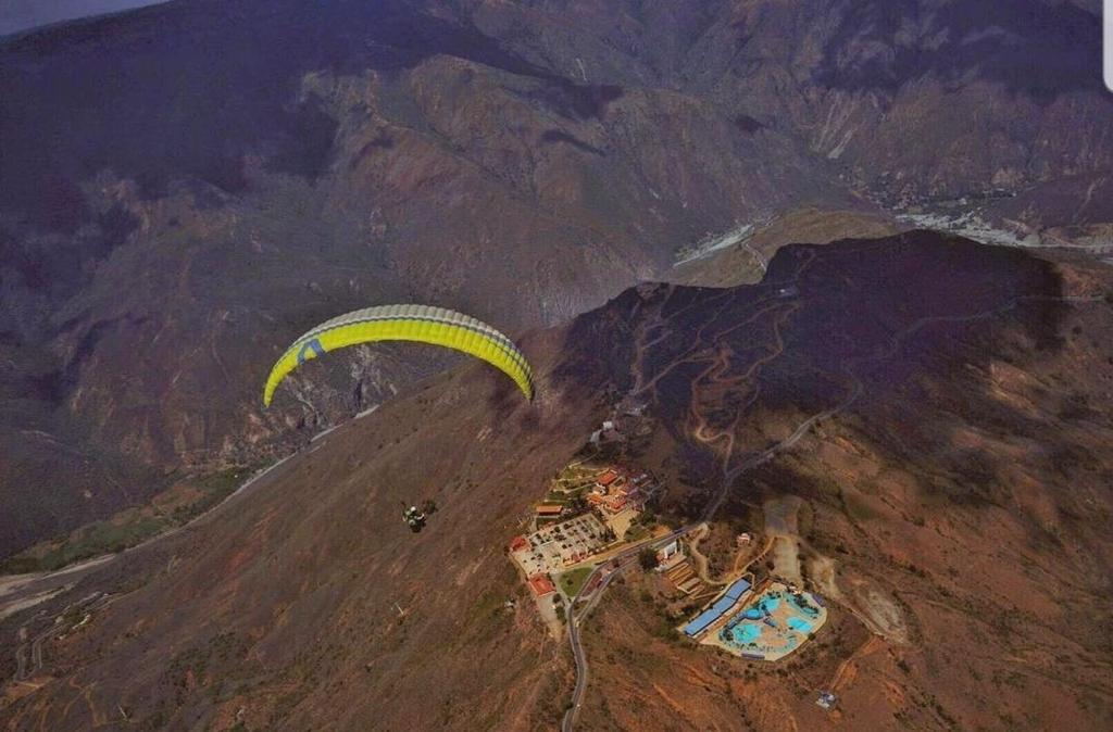 una visione aerea di un parapendio che vola sopra una montagna di La Mansion Hostel a San Gil